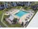 Overhead view of a community pool surrounded by lounge chairs, tables, and lush greenery at 5600 Beach Way Dr # 315, Sarasota, FL 34242