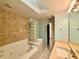 Bathroom featuring tile flooring, a tub with jets, tile surround, a glass block shower, and a vanity at 5615 Waneta Pl, Sarasota, FL 34231