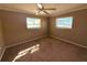 Bedroom featuring neutral walls, brown carpet, ceiling fan, and two windows with blinds at 5615 Waneta Pl, Sarasota, FL 34231