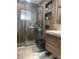 Contemporary bathroom featuring a walk-in shower with a black showerhead, stylish vanity, and wood-look tile at 5848 Milton Ave, Sarasota, FL 34243