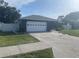 A single-story home featuring an attached two-car garage and a well-maintained lawn at 5848 Milton Ave, Sarasota, FL 34243