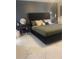 Stylish bedroom with a black platform bed, elegant side tables, and luxurious marble flooring at 5848 Milton Ave, Sarasota, FL 34243