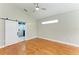 Bright bedroom with hardwood floors, a sliding barn door, and a vaulted ceiling with fan at 6423 Royal Tern Cir, Lakewood Ranch, FL 34202