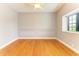 An empty bedroom has hardwood floors, chair rail detail, a ceiling fan, and a window at 6423 Royal Tern Cir, Lakewood Ranch, FL 34202
