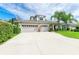 Beautiful two-story home boasts a three-car garage, a basketball hoop and well manicured landscaping with mature palm trees at 6423 Royal Tern Cir, Lakewood Ranch, FL 34202