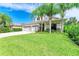 Charming two-story home with lush lawn and landscaping featuring a three-car garage and beautiful palm trees at 6423 Royal Tern Cir, Lakewood Ranch, FL 34202
