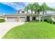 Charming two-story home with manicured lawn and landscaping featuring a three-car garage and beautiful palm trees at 6423 Royal Tern Cir, Lakewood Ranch, FL 34202