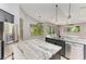 Large kitchen island with marble countertops, stainless steel appliances and pendant lighting at 6423 Royal Tern Cir, Lakewood Ranch, FL 34202