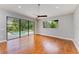 Living room with hardwood floors, light-grey walls, a large sliding glass door offering views of an outdoor pool at 6423 Royal Tern Cir, Lakewood Ranch, FL 34202