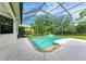Screened-in pool area featuring a waterfall feature and view of lush landscaping, creating an enjoyable outdoor space at 6423 Royal Tern Cir, Lakewood Ranch, FL 34202