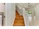 Bright staircase featuring wood steps and white railing leading to the home's upper level and a view of the pool at 6423 Royal Tern Cir, Lakewood Ranch, FL 34202