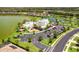 An aerial view of a lakefront community featuring a clubhouse, pool, tennis courts, and green spaces at 6507 Clairborne Ln, Bradenton, FL 34211