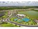 An expansive aerial view of a community with a lake, clubhouse, tennis courts and lush landscapes at 6507 Clairborne Ln, Bradenton, FL 34211