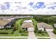 An aerial view of a charming home with a pond view, lush lawn, and brick paved driveway at 6507 Clairborne Ln, Bradenton, FL 34211