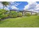 Lush green grass and tropical landscaping surround the home, perfect for enjoying the outdoors at 6507 Clairborne Ln, Bradenton, FL 34211