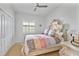 Cozy bedroom features a ceiling fan, shuttered windows, and a classic ornate bed frame and dresser at 6507 Clairborne Ln, Bradenton, FL 34211
