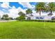 A well-manicured community entrance sign surrounded by lush green lawns and mature palm trees at 6507 Clairborne Ln, Bradenton, FL 34211
