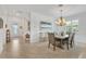 A modern dining room featuring an elegant chandelier, dining table, and open floor plan at 6507 Clairborne Ln, Bradenton, FL 34211