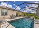 A luxurious screened-in pool features lounge chairs, dining, and open skies at 6507 Clairborne Ln, Bradenton, FL 34211