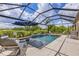 Relaxing screened-in pool area, complete with lounge chairs, umbrella, and private water view at 6507 Clairborne Ln, Bradenton, FL 34211