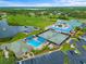 Overhead view showcasing a community pool, tennis courts and surrounding green spaces at 6507 Stone River Rd # 304, Bradenton, FL 34203