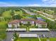 An aerial view of a condo community featuring well-maintained landscaping, a pond, and access to a nearby golf course at 6507 Stone River Rd # 304, Bradenton, FL 34203