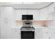 Clean and modern kitchen featuring white cabinetry, stainless steel appliances, and efficient design at 6507 Stone River Rd # 304, Bradenton, FL 34203