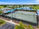 Aerial view of tennis courts and community pool, both adjacent to parking at 6507 Stone River Rd # 304, Bradenton, FL 34203