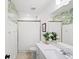 Stylish bathroom with white cabinetry, palm wallpaper, and framed mirrors at 6563 Silverstar Dr, Sarasota, FL 34240