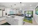 Open-concept living area featuring a kitchen island, dining space, and sliding doors to the pool at 6563 Silverstar Dr, Sarasota, FL 34240