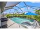 Inviting screened-in pool area with lounge chairs, a grill, and a clear blue pool at 6563 Silverstar Dr, Sarasota, FL 34240