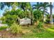 Woodside Village East community sign surrounded by lush landscaping adds charm and curb appeal at 6832 Woodwind Dr # 53, Sarasota, FL 34231