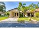 Charming single-story home with well-manicured lawn, tropical palm trees, and convenient carport at 6832 Woodwind Dr # 53, Sarasota, FL 34231