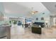 Spacious living room with neutral decor, built-in shelving, ceiling fan, and access to sunroom at 6832 Woodwind Dr # 53, Sarasota, FL 34231