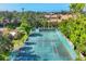 Aerial view of tennis court with well maintained net and fences surrounded by mature trees at 6832 Woodwind Dr # 53, Sarasota, FL 34231