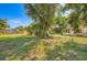 Large backyard featuring well-maintained lawn, mature trees and wood fence at 718 17Th E St, Bradenton, FL 34208
