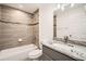 Tiled bathroom featuring a shower-tub combo, granite counters, and ample lighting at 718 17Th E St, Bradenton, FL 34208