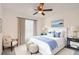 Bright bedroom features a plush bed with blue accents, side tables, and ottomans at 718 17Th E St, Bradenton, FL 34208