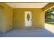 Covered front porch and decorated front door with yellow exterior paint at 718 17Th E St, Bradenton, FL 34208