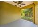 Covered patio with neutral colors, ceiling fan and green scenery in background at 718 17Th E St, Bradenton, FL 34208