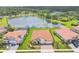 Aerial view of homes with landscaped yards in a residential community and pond at 7228 Great Egret Blvd, Sarasota, FL 34241
