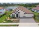 Aerial view of a single-Gathering home with a tile roof, brick driveway, and serene lake views at 7228 Great Egret Blvd, Sarasota, FL 34241