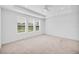 Bright bedroom boasts large windows, neutral carpeting, and tray ceiling at 7228 Great Egret Blvd, Sarasota, FL 34241