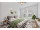 Staged bedroom with a grey bed frame, a green coverlet and view of backyard at 7228 Great Egret Blvd, Sarasota, FL 34241