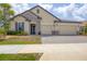 A single-Gathering home boasting a tile roof, stone accents, a brick driveway, and well-manicured landscaping at 7228 Great Egret Blvd, Sarasota, FL 34241