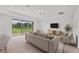 Bright living room with large windows offering serene pond views, neutral decor, and carpet flooring at 7228 Great Egret Blvd, Sarasota, FL 34241