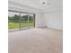 An open living room with carpet flooring, recessed lighting, and sliding glass doors with a view of the lake at 7228 Great Egret Blvd, Sarasota, FL 34241