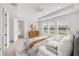 Bright main bedroom with contemporary decor features an accent cabinet and a large window with scenic outdoor views at 7228 Great Egret Blvd, Sarasota, FL 34241