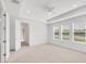 Spacious main bedroom features neutral carpet, tray ceiling with fan and lots of natural light from the three windows at 7228 Great Egret Blvd, Sarasota, FL 34241