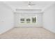 Spacious main bedroom features neutral carpet, tray ceiling with fan and lots of natural light from the three windows at 7228 Great Egret Blvd, Sarasota, FL 34241